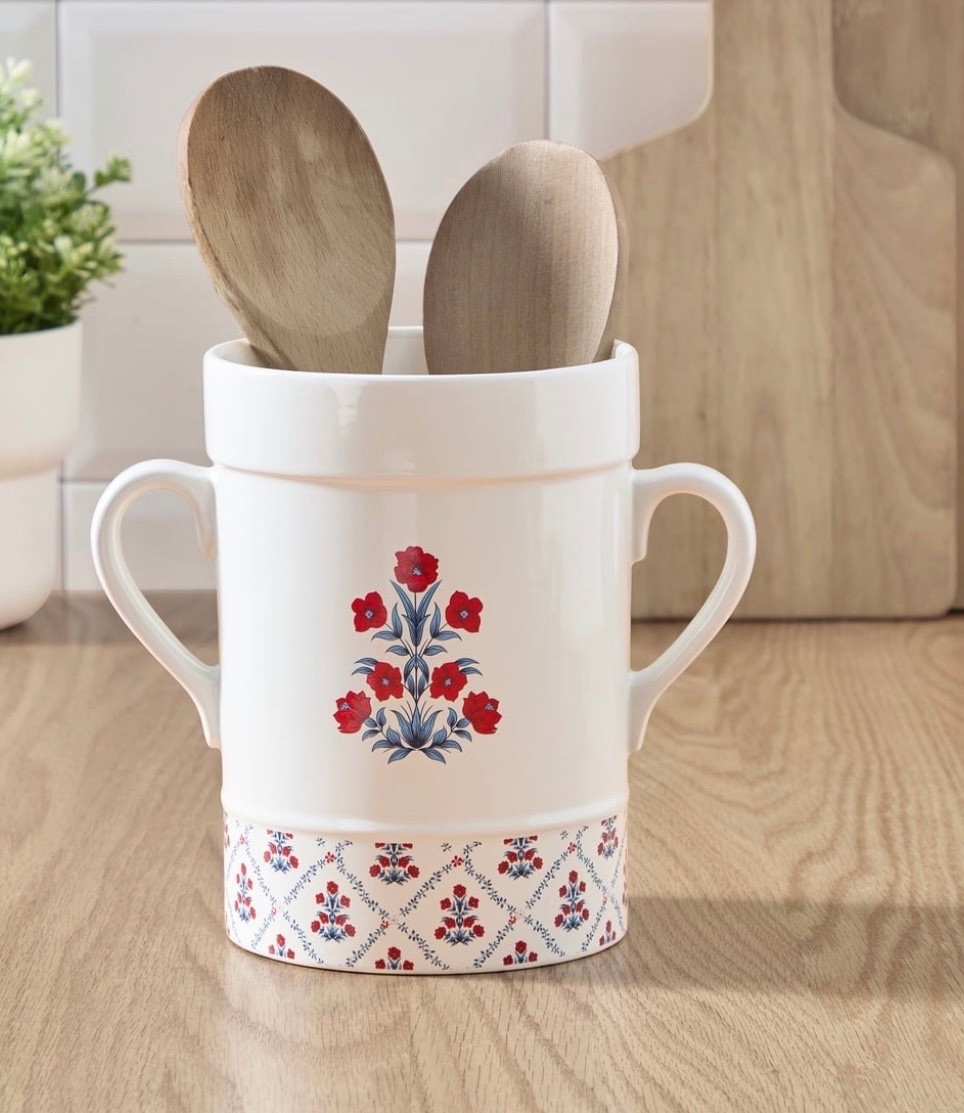 The My Texas House Poppy Trellis Ceramic Utensil Crock adds a cheerful pop of color to your kitchen with its red, white, and blue floral design. This seven-inch crock features a bright poppy motif on the front and a coordinating trellis pattern around the base, bringing a charming decorative touch to counters and cooking spaces. The wide opening offers plenty of room for spatulas, spoons, whisks, and other everyday tools, helping keep your utensils organized and easy to reach. Its sturdy ceramic shape sits securely on the counter and pairs well with both seasonal and year-round decor. Whether you are prepping for a summer gathering or cooking a simple weeknight meal, the My Texas House Poppy Trellis Ceramic Utensil Crock keeps your essentials close at hand

#LTKmorningroutine #LTKHome #LTKSeasonal
