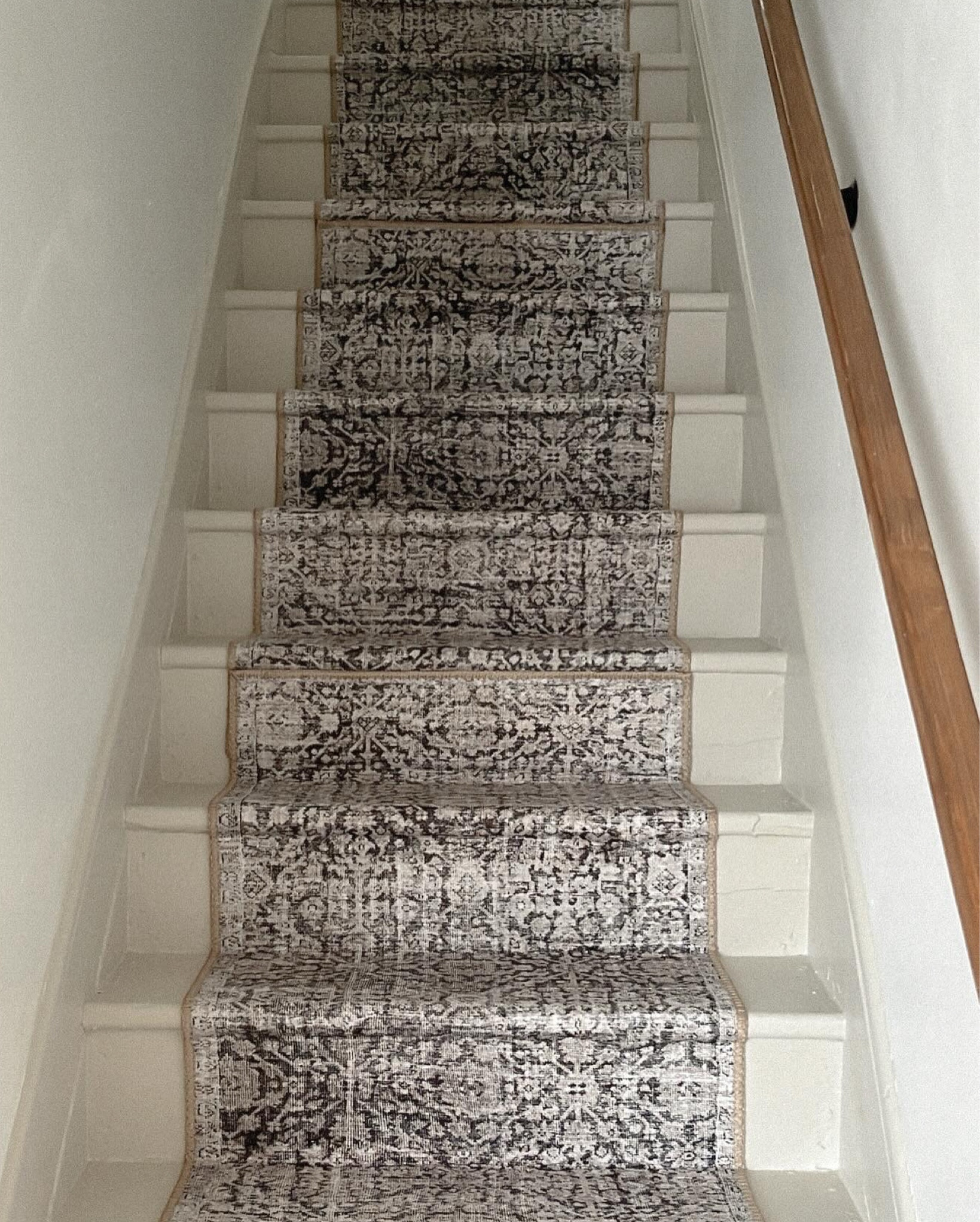 Starting at the top in the center, staple your rug in securely and then pull tightly and staple again in where the riser meets the next stair tread (step). Apply the carpet tape on the top of each step and work your way down making each seam in the same spot by overlapping the rugs! 