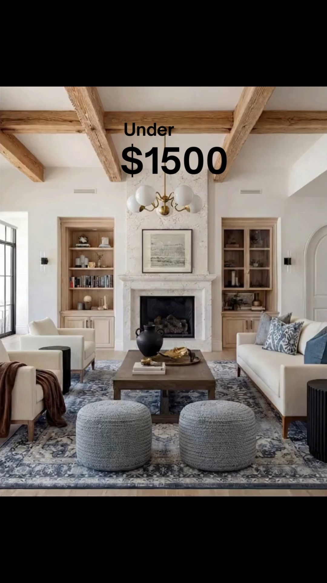 Shop the Look:
• Marble fireplace surround
• Cream armchairs + sofa
• Blue patterned lumbar + throw pillows
• Chunky knit ottomans
• Solid wood coffee table
• Black ceramic vase decor
• Distressed blue traditional rug
• Wood built-ins with glass fronts
• Warm wood ceiling beams
Brown throw blanket 
White decor books
Brass oval tray
Black decor bowl
Rounded globe chandelier 

#LTKFindsUnder100 #LTKHome #LTKSaleAlert