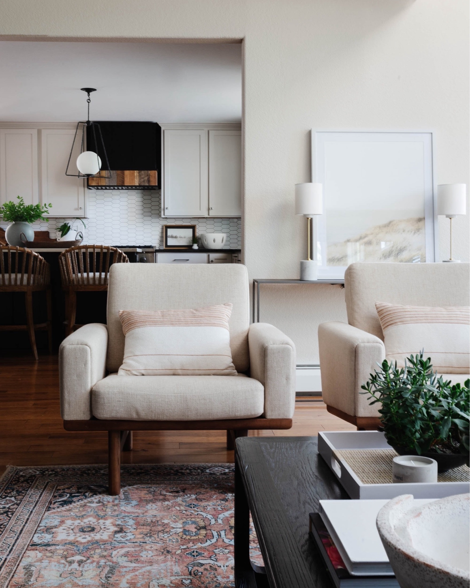 California Casual meets contemporary in this relaxed, layered living room. 🤍
 
The original layout felt small and cramped, and with this being our clients’ primary entertaining space, maximizing seating was a priority. By rethinking the furniture plan and pushing the seating farther back, we were able to comfortably fit two sofas while creating a room that feels much more open and inviting.
 
The design itself was all about finding the balance between two different style preferences: one client loved the warm, organic ease of California Casual, while the other gravitated toward cleaner, more contemporary lines.
 
Their authentic Hans Wegner chairs became the perfect jumping-off point. We layered in warm woods, woven textures, vintage-inspired pieces, a mix of light and dark upholstery, and an earthy palette to create a space that feels collected and relaxed,but still clean and contemporary.
 
And because this is a home shared with some very loved dogs, performance upholstery and durable rugs were every bit as important as the pretty things. Because a beautiful room should still work for real life. 🐾
 
Design // @peggyhaddadinteriors
Photography // @KaraDeYoung