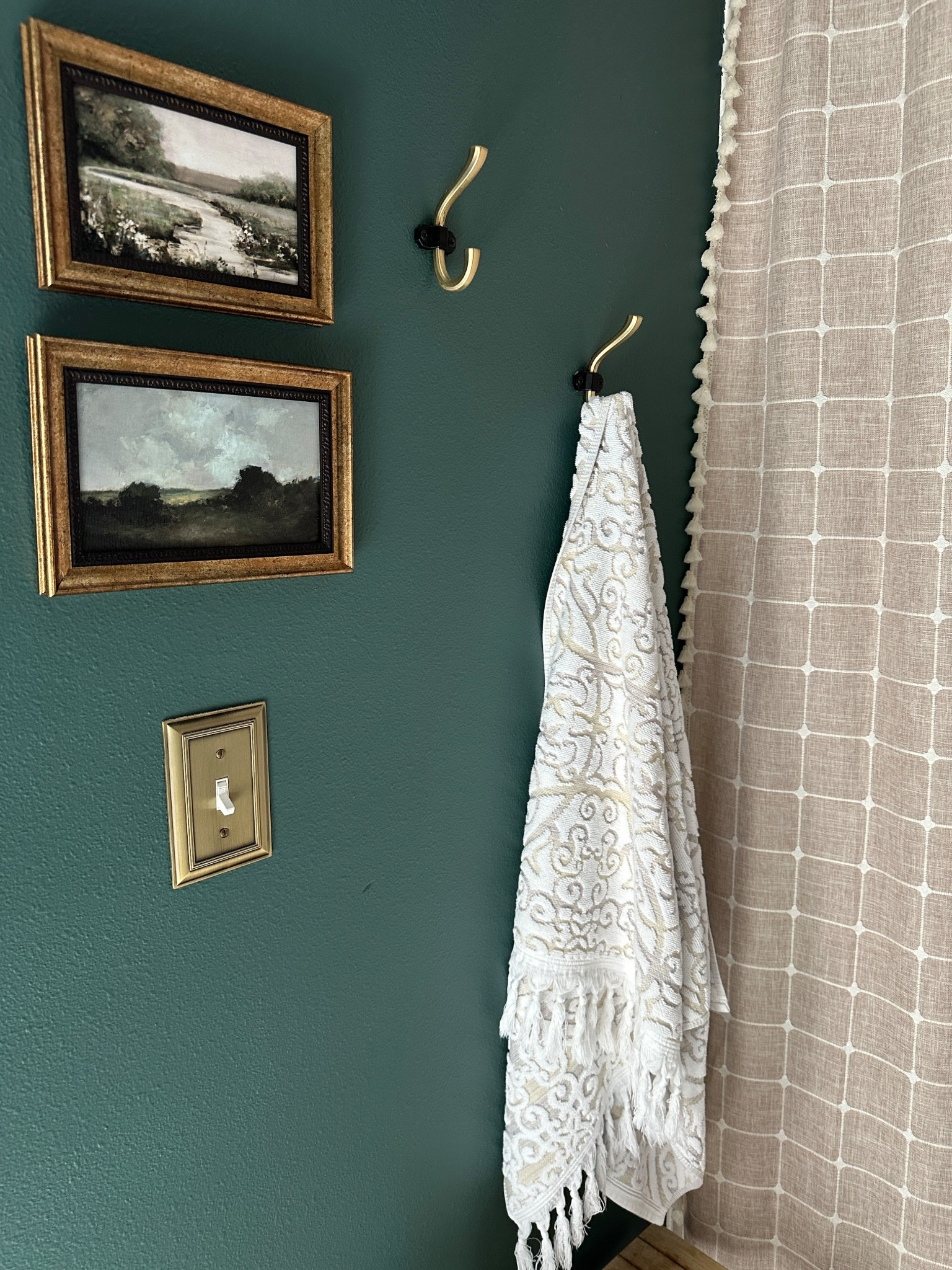 Bathroom refresh with moody green wall paint and taupe, brass and black accessories.

Antique brass switch plates were an easy upgrade.

Gold frame landscape art prints were a serene touch.

And textiles like a shower curtain and patterned bath towels brought warmth and coziness.

Kids bathroom | guest bathroom | home decor | antique decor | antique modern | vintage look 

#LTKOver40 #LTKHome #LTKFindsUnder50