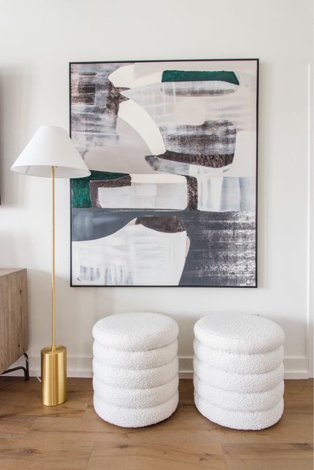 Oversized art with boucle stools and a brass floor lampp