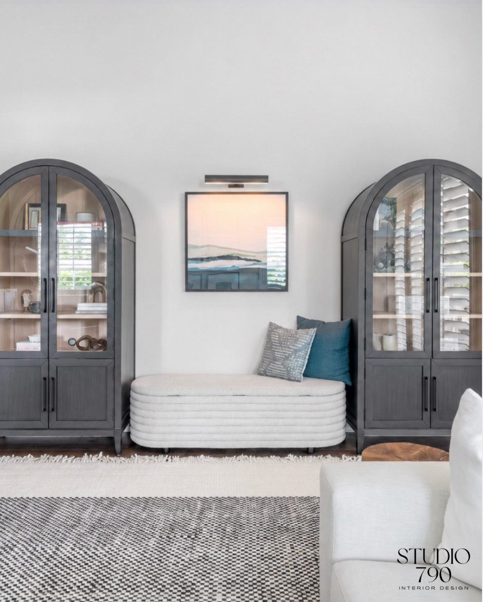 A collected corner with strong architectural lines. Arched cabinetry, a sculptural bench, layered art, and warm contrast bring the whole space together. 

 #LTKHome