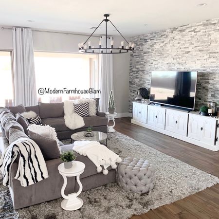 Our family room at Modern Farmhouse Glam. Gray sectional sofa couch, gray shag rug, touched it ottoman, marble coffee table in white, modern farmhouse round wagon wheel iron chandelier, media console table, we put two of these together in the bedroom and it looks very similar.

#LTKhome