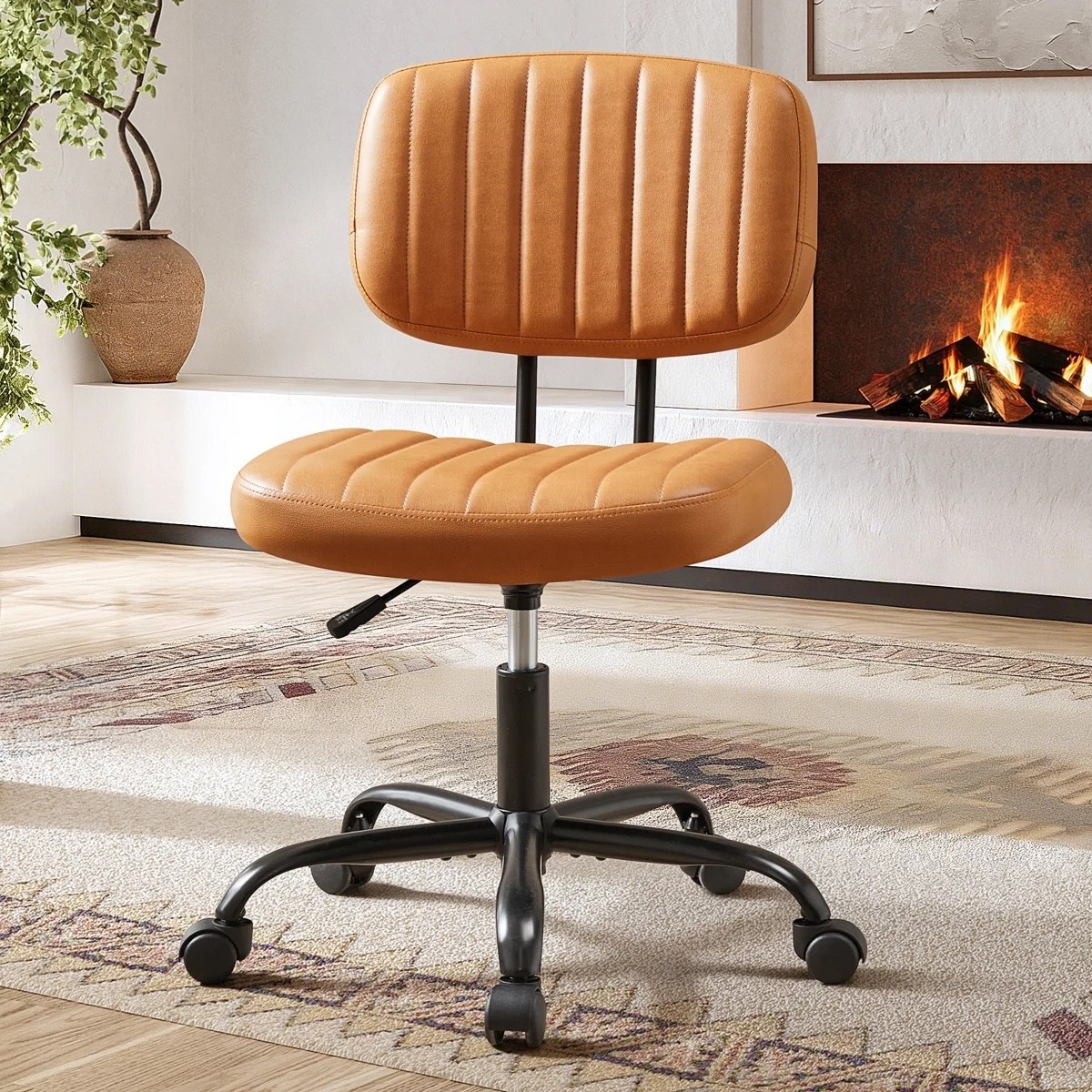 caramel faux leather office chair from Wayfair has such a warm, pulled-together feel without looking like a typical desk chair. The armless shape, vertical channel stitching, rounded seat, swivel base, and black casters keep it simple but still really stylish. I like it paired with the vintage-style patterned rug, fireplace, oversized vase, and greenery for a home office that feels more like part of the room. And I t’s $57.99 right now!