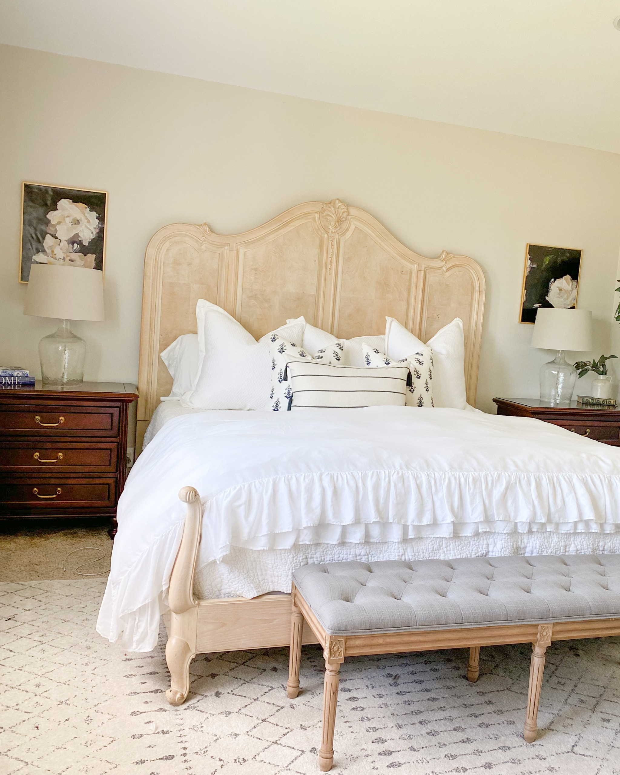 My bedroom. Jennuinehome. Light traditional bedroom. Master bedroom. Main Suite bedroom. Tufted bench. Light blue rug. Dark nightstand. Glass lamp. Dark floral art  

#LTKhome