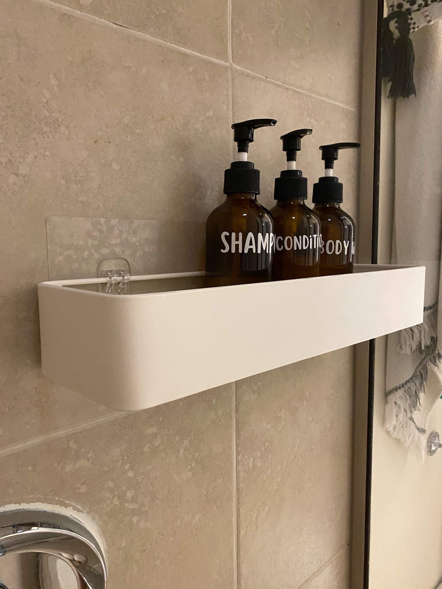 This shower shelf holds my refillable glass Amber bottles so well. The refillable bottles hold my shampoo, conditioner, and body wash in the guest bathroom! #bathroomorganization #bathroommusthaves #ecofriendly 