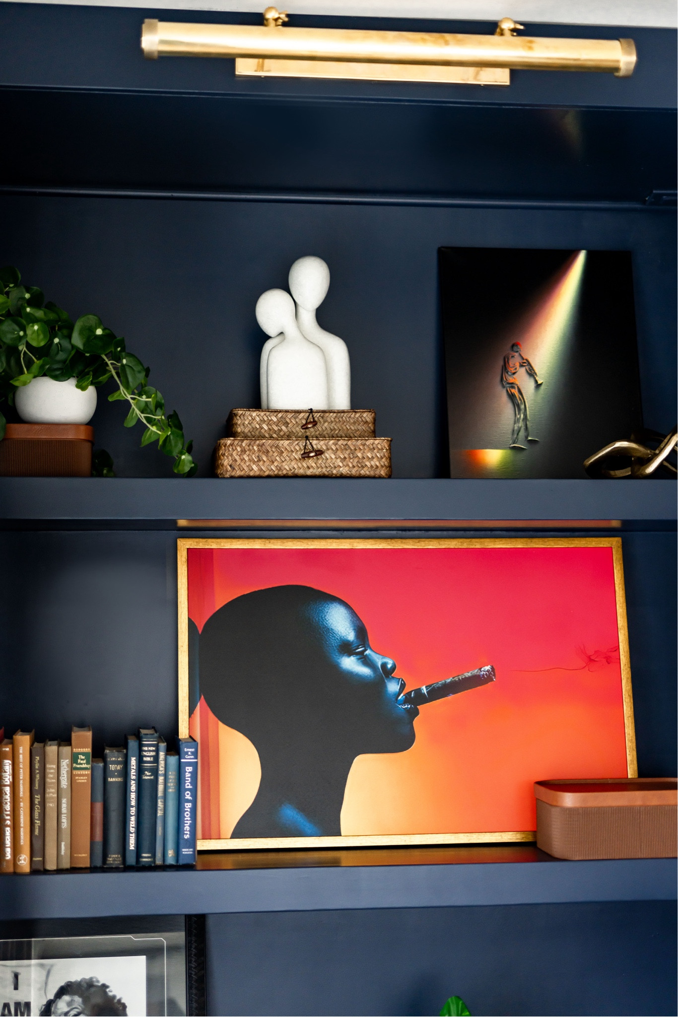 Bookcase styling on navy bookcase with art of woman smoking cigar

#LTKHome