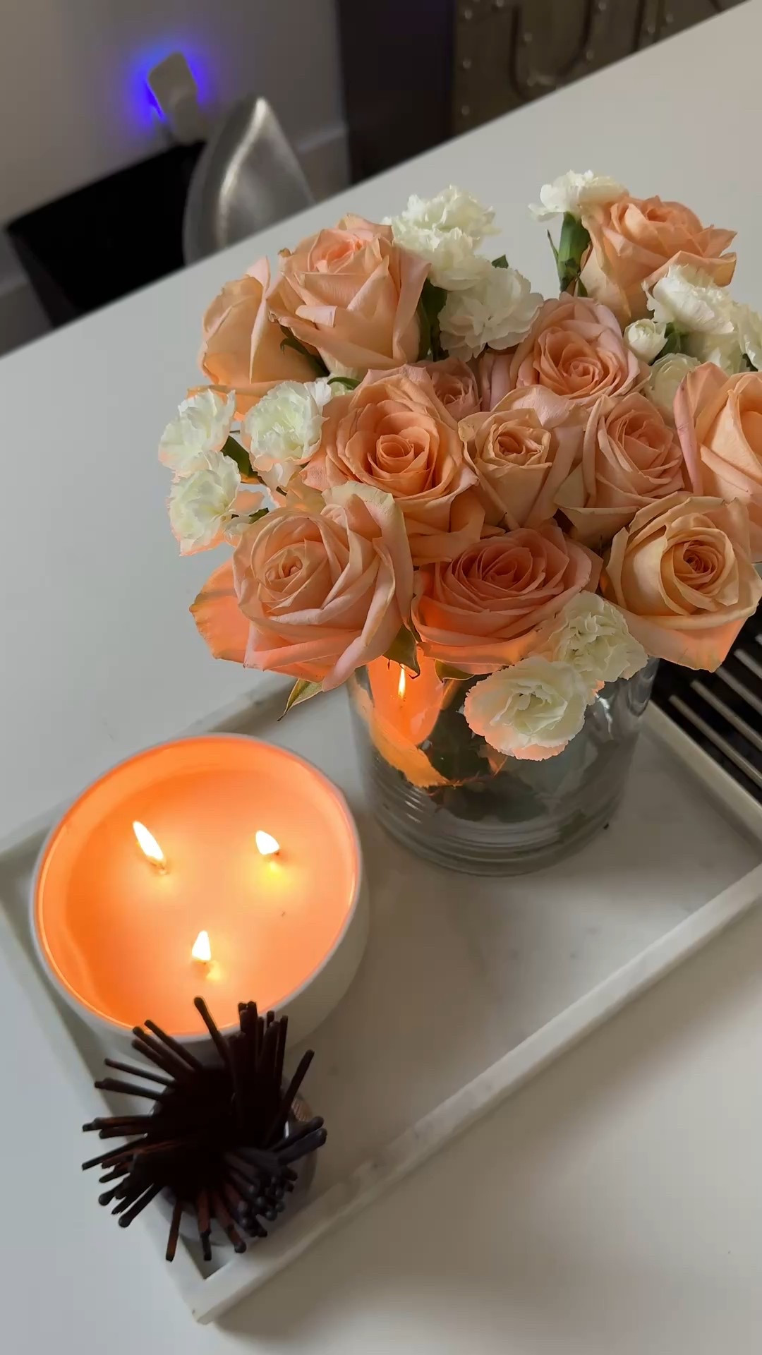 Soft Peach Roses & Candlelight Aesthetic – Cozy Romantic Home Decor


A dreamy, romantic home decor setup featuring a bouquet of soft peach roses with delicate white accent flowers arranged in a clear glass vase. Styled on a white tray beside a glowing three-wick candle and modern match holder, this cozy floral arrangement creates the perfect warm ambiance for a date night at home, or a relaxing self-care evening. The neutral and blush tones add a soft, feminine aesthetic ideal for modern kitchen or bedside styling.


#LTKmorningroutine #LTKValentine #LTKdayinmylife