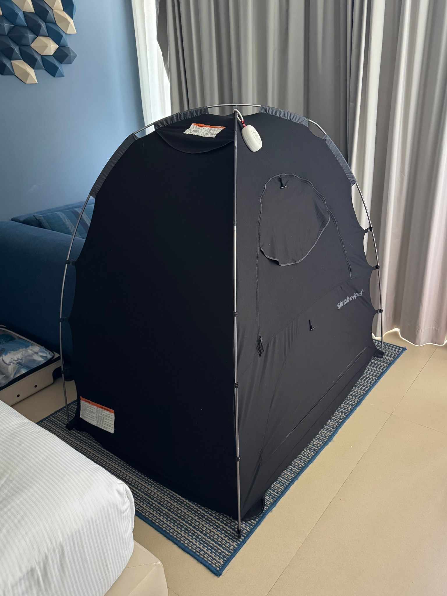 I feel like I share this every trip we go on but I always get so many questions! This is our toddlers nap set up (currently napping inside when I snapped this!)

It’s a slumberpod that fits over a crib or toddler mattress to create a blackout experience for them. It is our number one travel rec! Our boy can go to sleep and we can keep all of the lights on & walk around our hotel room like normal🙌🏼

He uses the slumbertot and sound machine from slumberpod too! Everything linked here❤️

#LTKTravel #LTKFamily #LTKKids