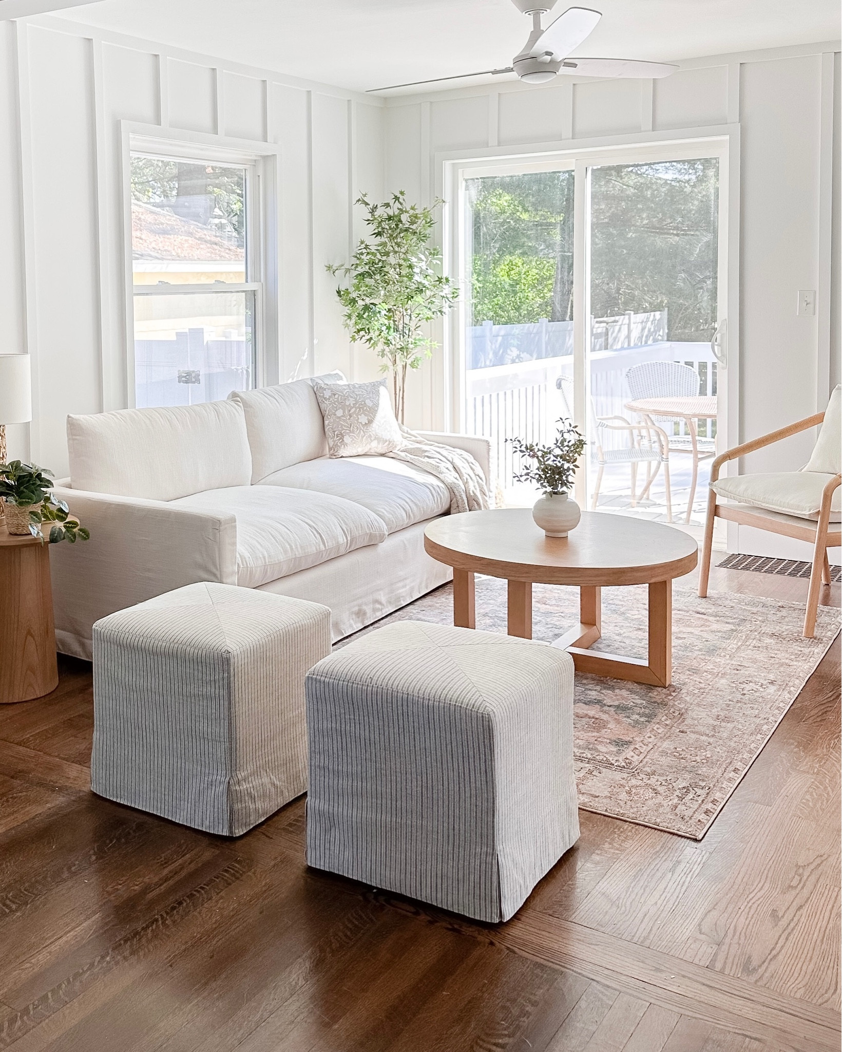 Living room at our Guest Cottage project!🤍 

~~~~~
Living room furniture, neutral decor, white sofa, blue vintage rug, round coffee table, round wood end table, faux tree, white ceiling fan, striped ottomans, serena and lily, coastal farmhouse, neutral home decor

#LTKhome #LTKFind #LTKsalealert
