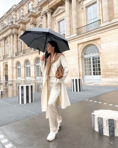 Kat Jamieson of With Love From Kat wears a fall outfit. Neutral coat, neutral sweater, white jeans, brown sweater, white sneakers, sunglasses, brown clutch  

#LTKSeasonal #LTKstyletip