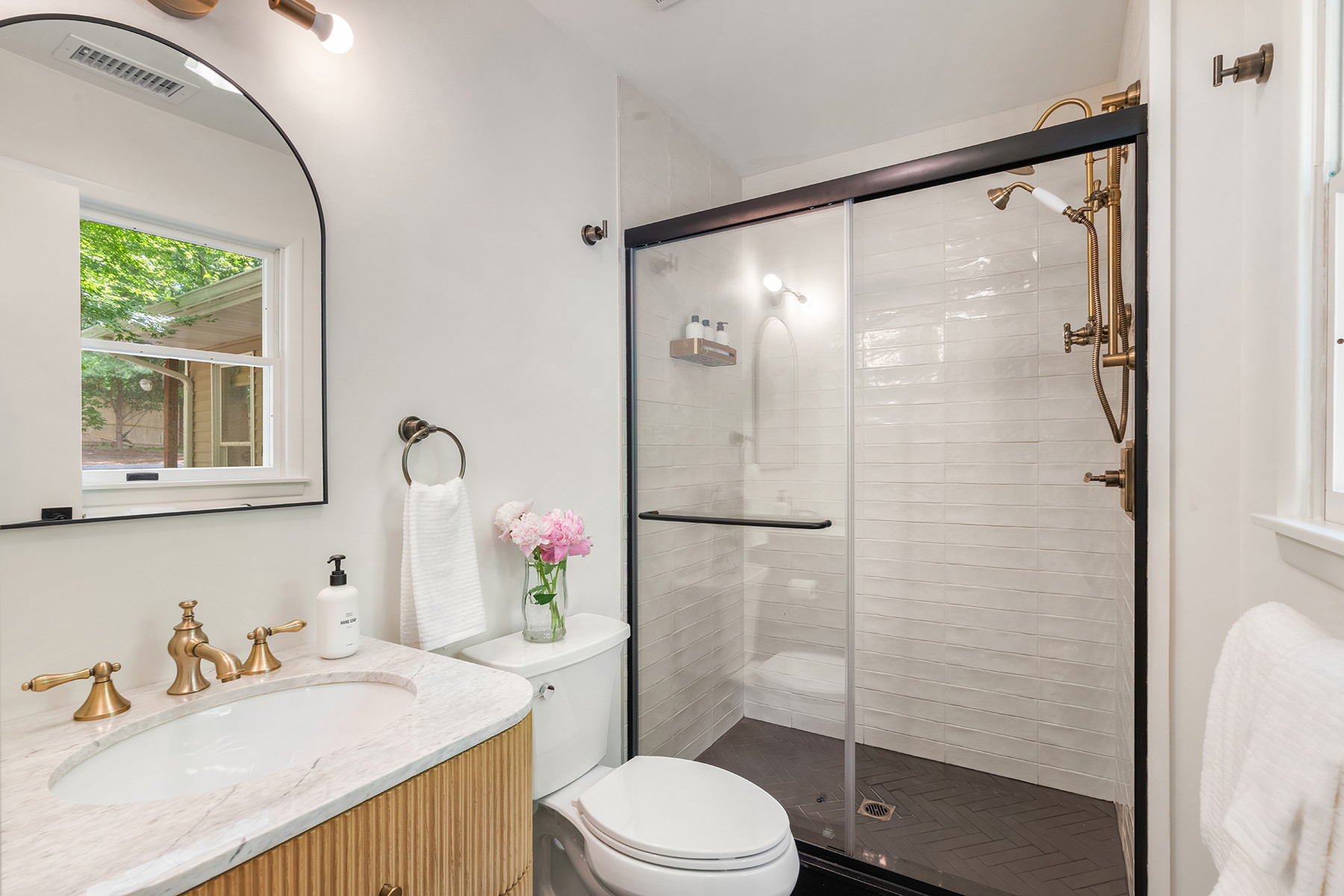 This combo is one I’ve done a few times now: black floor tile with this vanilla home depot wall tile is a perfect combo for a walk in shower.  The wood vanity keeps it from being overly modern. 
Linked some exact materials and some similar finds, below. 

 #bathroomdesign #bathroomdecor #bathroominspo #modernbathroom #homedecor #interiordesign #neutralhome #designinspiration 

#LTKSaleAlert #LTKHome