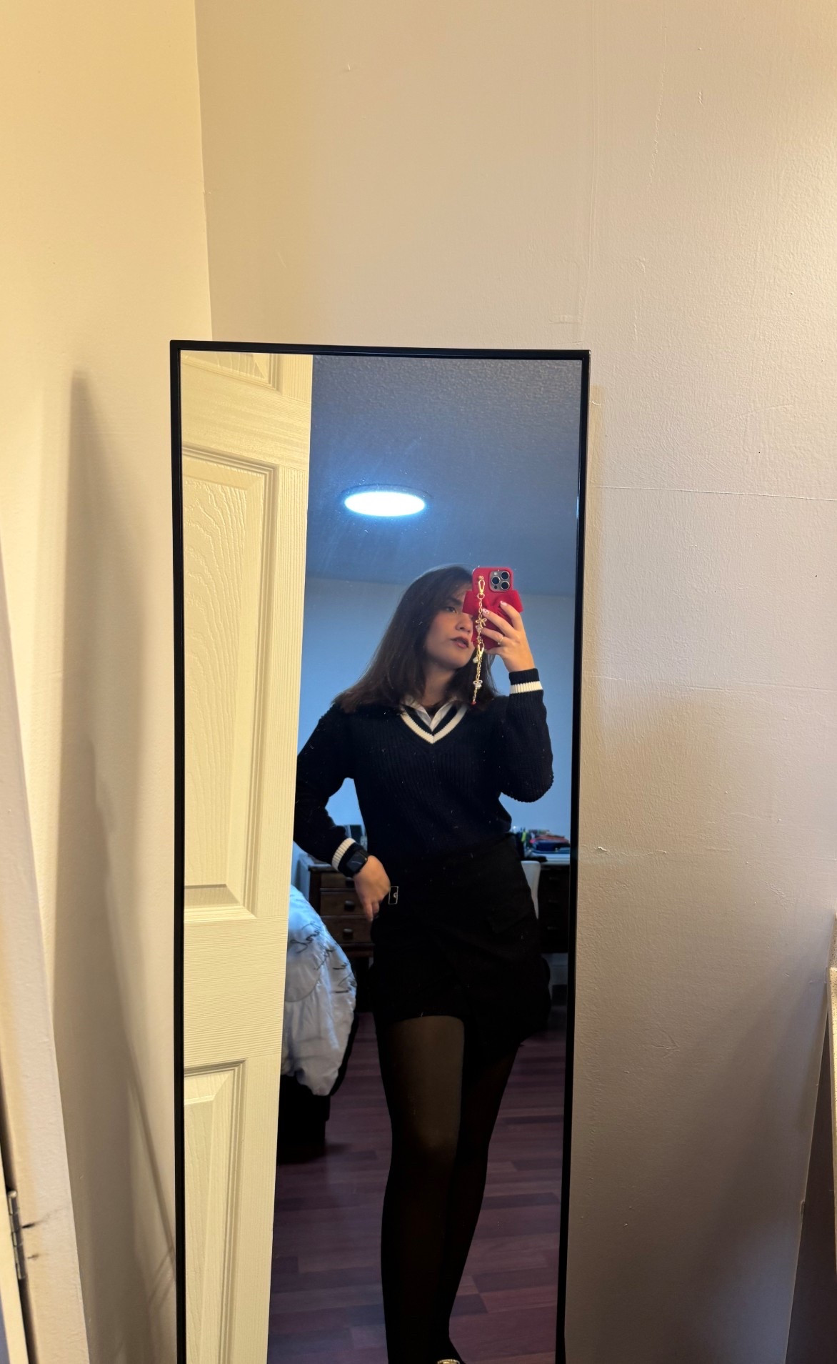 Cold weather uniform 🖤

 What looks amazing

• The V-neck sweater with the stripe detail
Gives that classic academic/preppy vibe — elegant but still youthful.

• Black mini + black tights
Flattering, slimming, and makes the whole look feel sleek and put together.

• The red phone case adds a pop of color
Honestly it works — it brings warmth to the outfit without overpowering it.

• Your hair down + soft makeup
Balances the structured sweater and keeps the look feminine.

#LTKgrwm #LTKCyberWeek #LTKootd