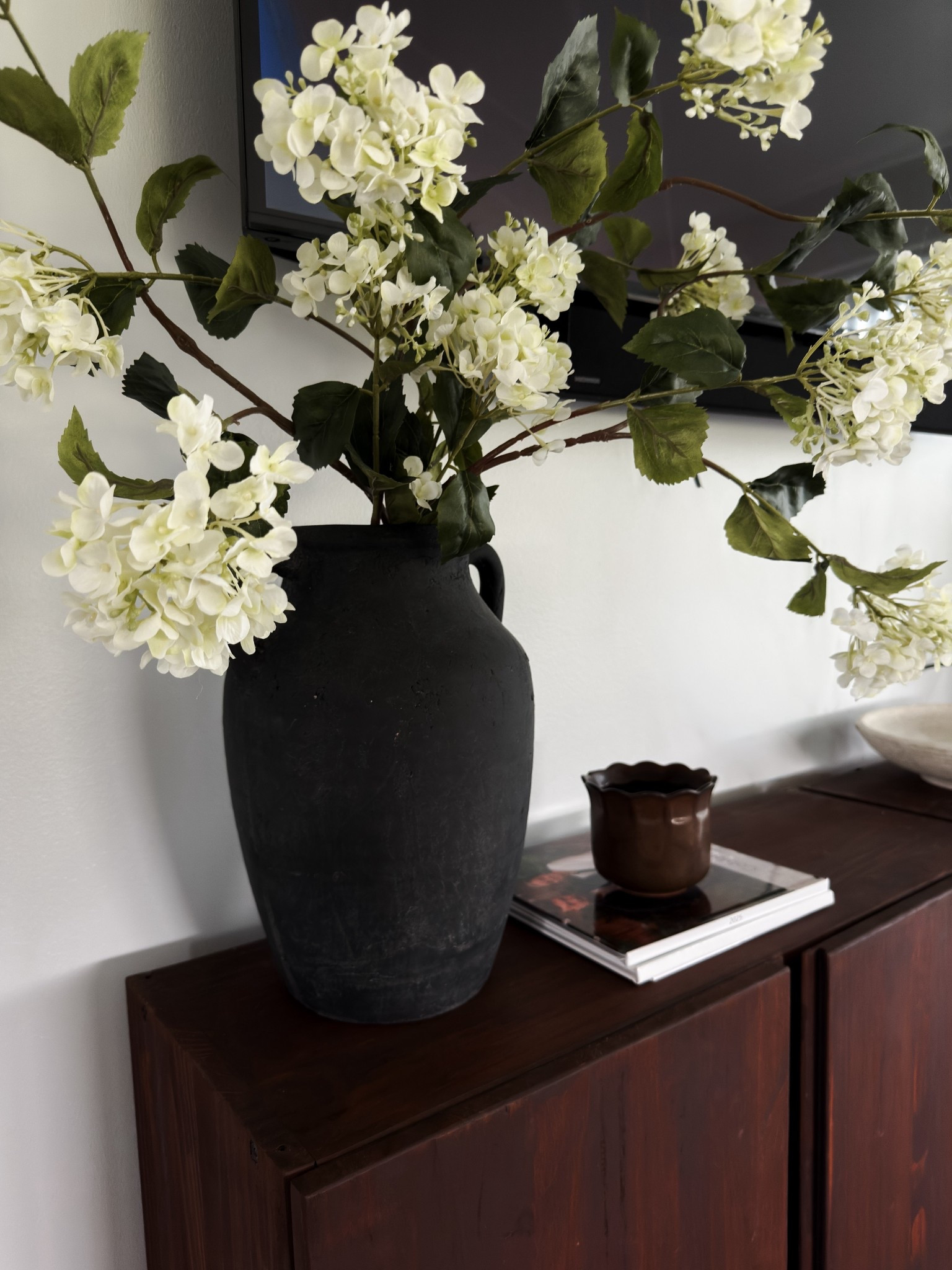 Large faux bouquet to help "cover" the tv up more🤭


••home decor •neutral decor •organic modern home •moody decor •faux stems •hydrangeas •decor 

#LTKSeasonal #LTKHome #LTKOver40