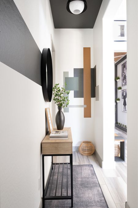 Entryway/Hallway Decor Ideas featuring a console table, black vase, design books, faux greenery, art, black modern mirror, woven basket and rubber rug  

#LTKhome