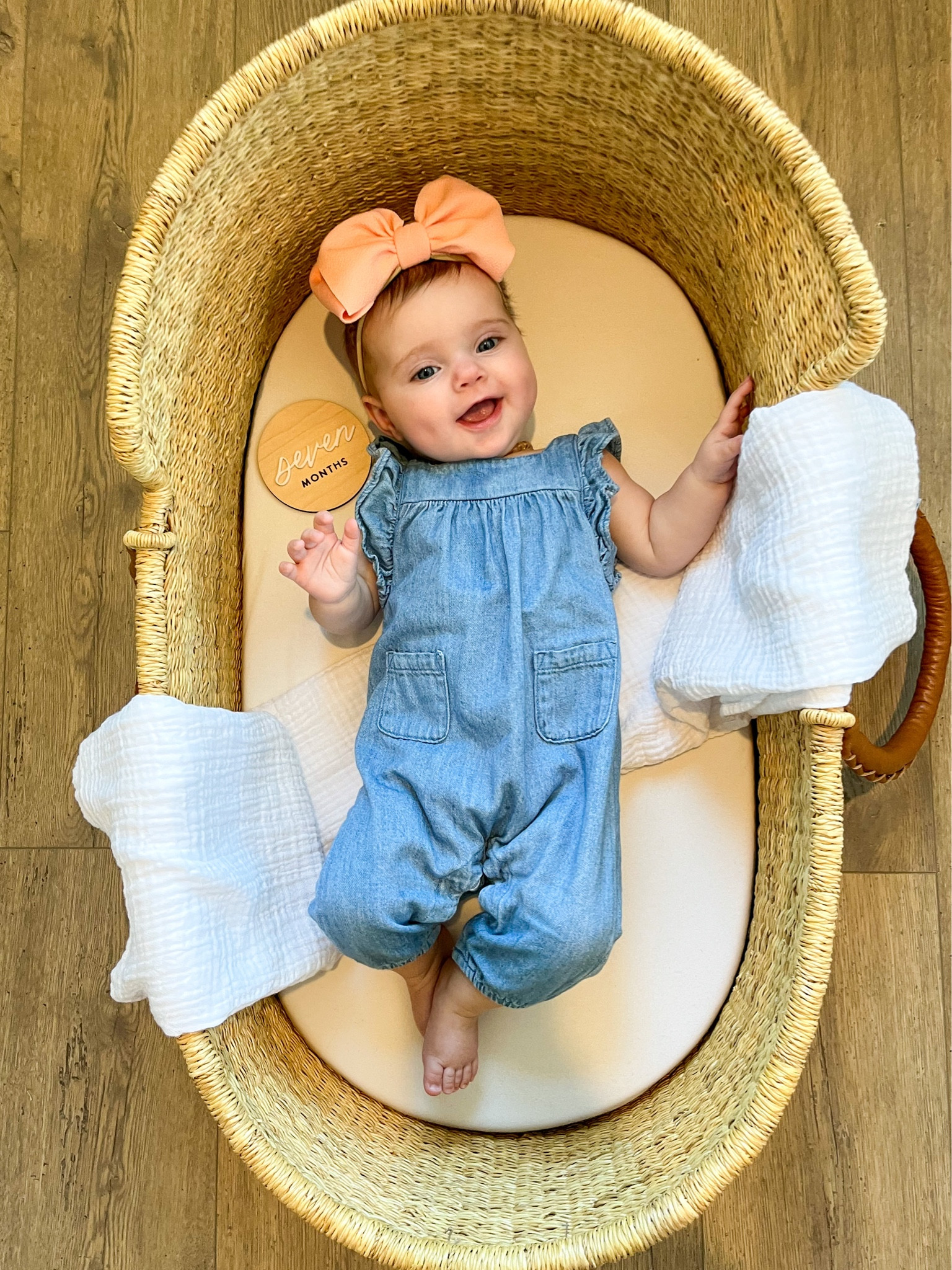 Monthly baby photo in a basket with denim jumpsuit and peach Stevie J’s “Julia” bow on nylon