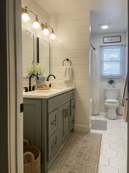 Our kids bathroom has a 48” vanity base that we converted into a double vanity.  Simply buy a custom quartz countertop and add two small kohler sinks.  

Black bathroom bridge faucets.  Gray vanity base.  Kohler sinks.  Black bathroom mirrors.  Brass bathroom lights.  Hexagon tile.  Kohler toilet.  Brass hardware.  

#LTKstyletip #LTKhome #LTKfamily