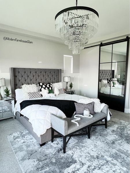 Master bedroom at Modern Farmhouse Glam. White and gray rug, tufted headboard, platform bed, king bed, mirrored nightstands, crystal chandelier, metal mirrored sliding door, bench, bedding, sheets 


#LTKHome