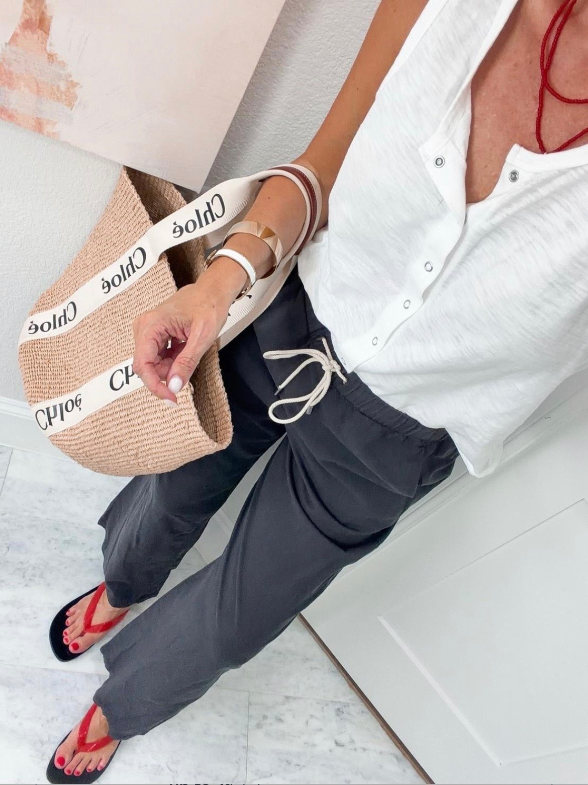 This is the kind of outfit I throw on when I want to feel put together without thinking too hard. The lightweight drawstring pants keep you cool, the textured white top adds just enough detail, and the red accessories give the whole look a fun pop of color for everything from vacation days to lunch with friends.

Drawstring pants, white sleeveless top, casual summer outfit, vacation style, everyday summer fashion, red flip flops, woven tote bag, resort outfit, comfortable travel outfit, effortless summer style, HauteandHumid

#LTKOver40 #LTKTravel #LTKSeasonal