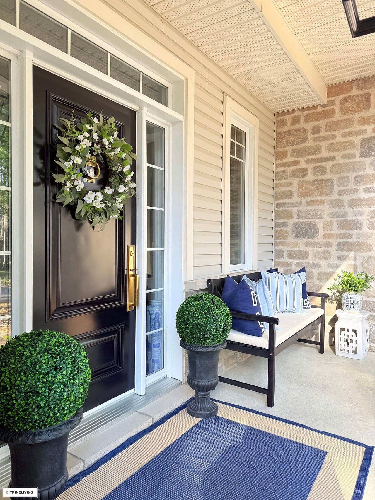 Front porch refresh with classic urns, boxwood topiaries, outdoor bench, chic pillows, lush wreath and more!