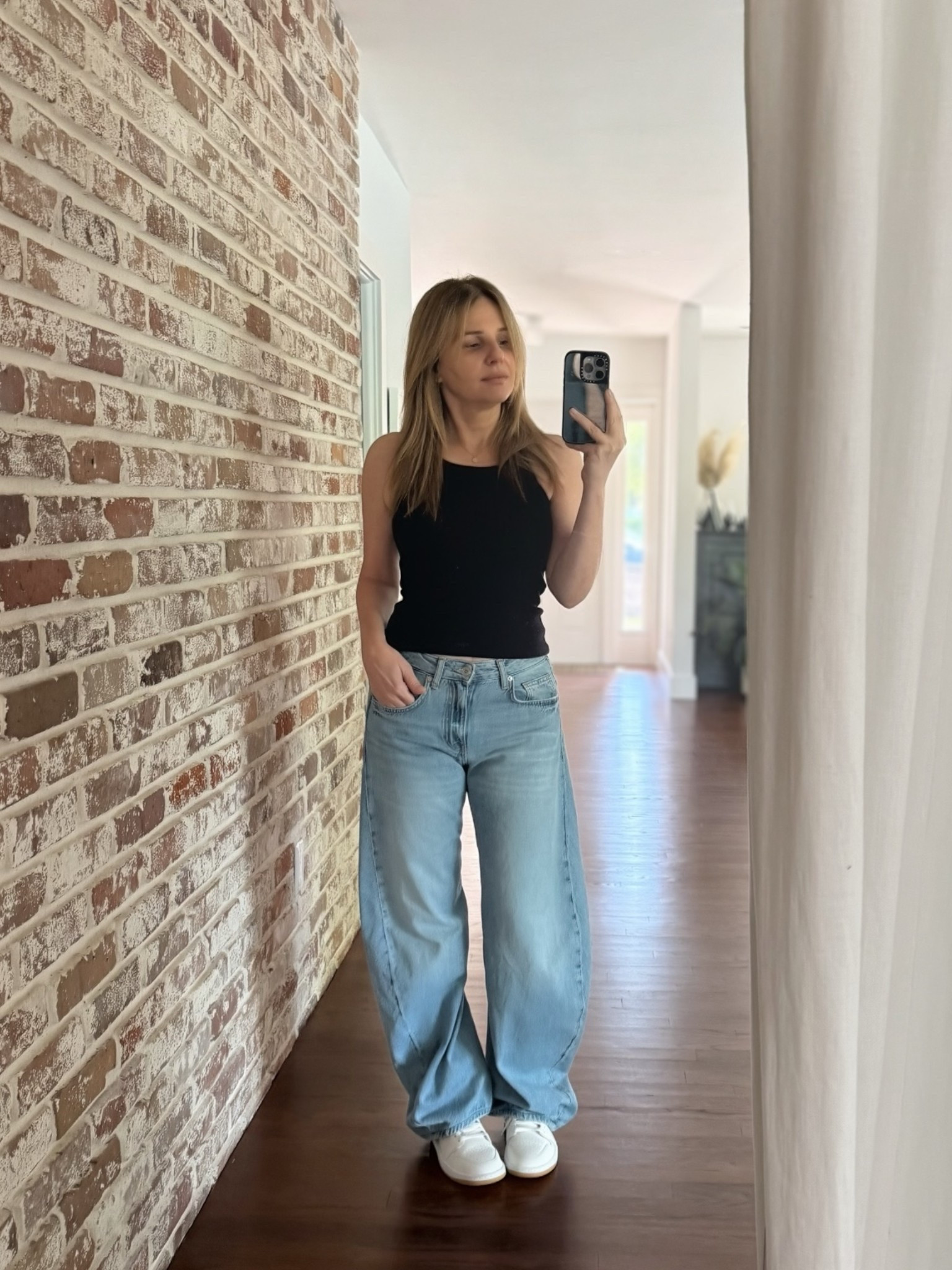 Wearing a pair of light denim baggy barrel (almost horseshoe) jeans w a high neck ribbed racerback tank in a dark charcoal, both from Zara. Sneakers are my @Nike US Air Jordan 1 mid sneakers

#LTKootd #LTKdayinmylife #LTKSaleAlert
