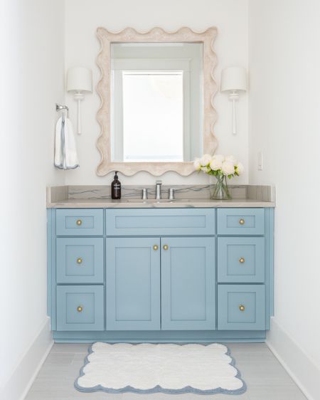 Our bathroom decorated for spring! We love the gold knobs on our blue cabinets, and I added these faux peonies, scalloped bath mat, and scalloped hand towel for spring! Also linking our white sconces and scalloped wood mirror. See our full spring home tour here: https://lifeonvirginiastreet.com/2024-spring-home-tour/.
.
#ltkhome #ltkseasonal #ltksalealert #ltkstyletip #ltkfindsunder50 #ltkfindsunder100 coastal decor, spring decorating ideas

#LTKsalealert #LTKhome #LTKSeasonal