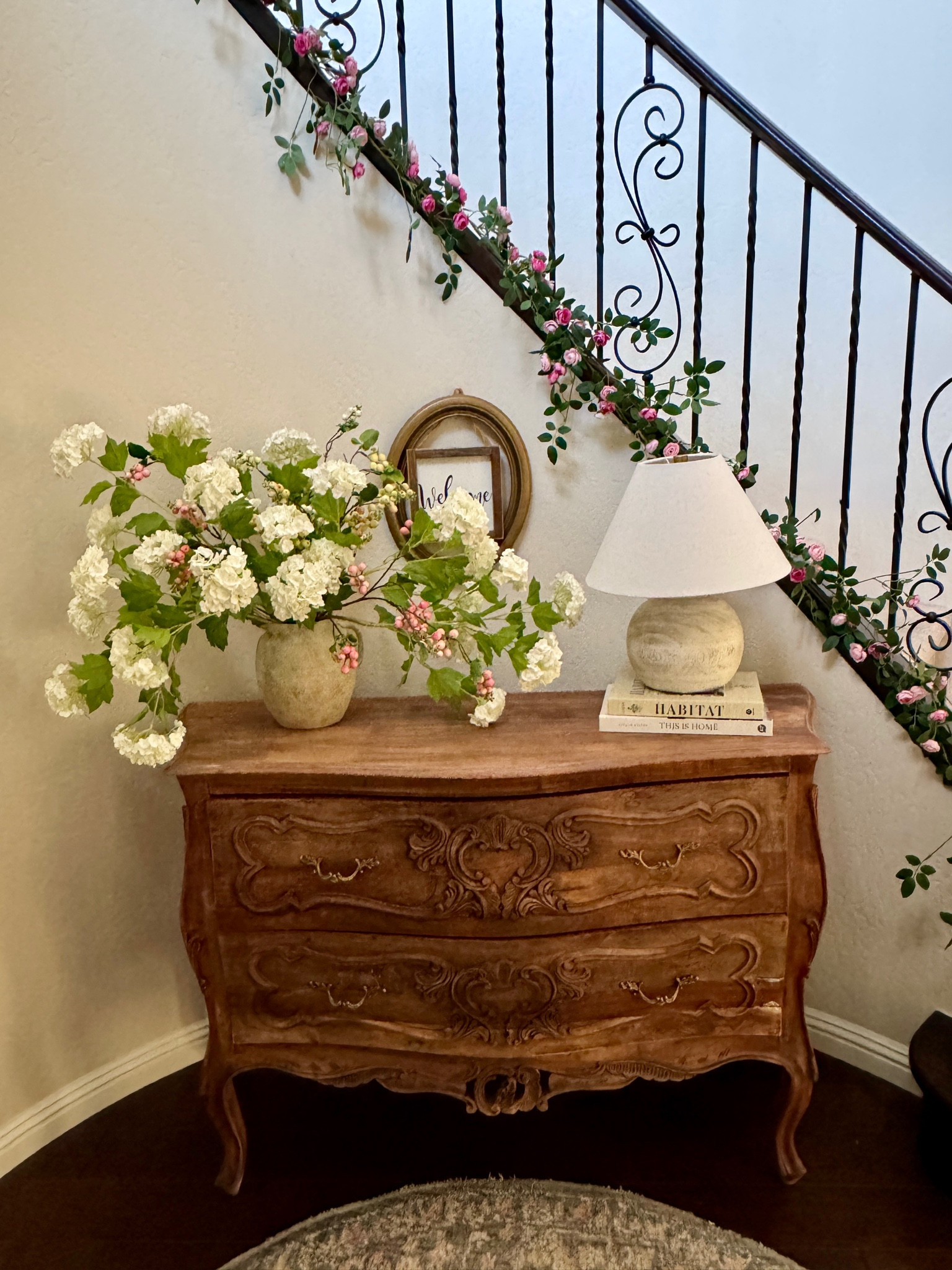 My current entryway decor 

I have a small circular front entryway. But enough room for this salvaged French dresser that I refinished. I added some spring snowball hydrangeas and a dainty rose garland down the staircase for a spring touch. 

#LTKFindsUnder50 #LTKHome