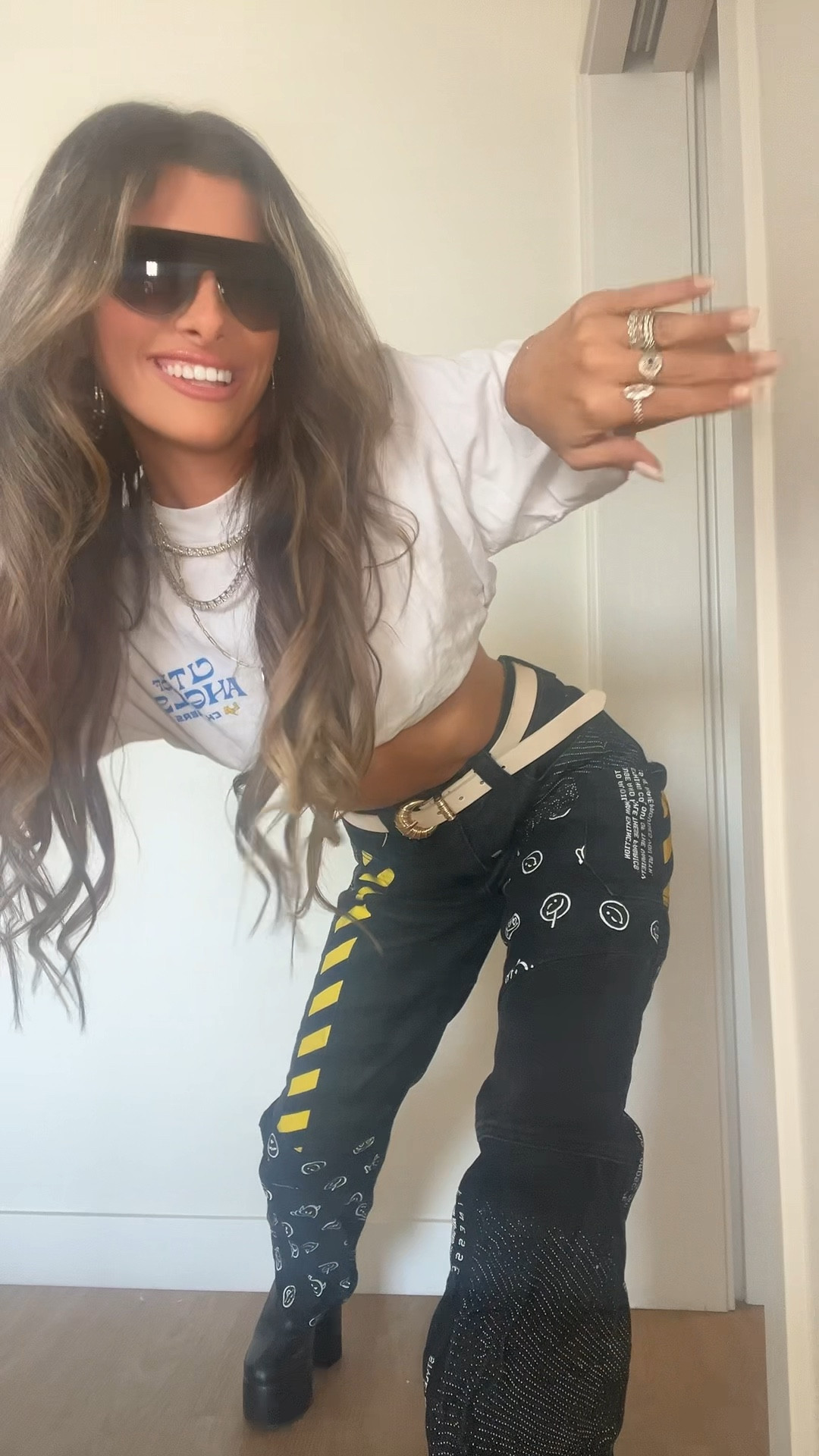 Chargers game day = fashion show 💙💛⚡️ GRWM for the first game of the season against the Chiefs!

Started the day cozy in my favorite off-white sweatpants (sadly sold out, but I linked a super similar pair!) with a matching Joah Brown sports bra — my go-to athleisure brand for elevated basics.

Then I switched it up with my statement game-day look: black graphic denim from Akira featuring the bold yellow + smiley details (these got me SO many compliments at the stadium 👀). I paired them with a simple Chargers tee from team merch, but tucked it into my sports bra to add a little edge + show a hint of skin.

To sparkle it up, I layered all of my favorite Melinda Maria jewelry ✨ and finished with game-day essentials: sleek black sunnies + black platform boots. Both are staples for me on any stadium day.

Linked everything I can for you… who else is dressing up for every game this season?

#LTKPetite #LTKActive #LTKStyleTip