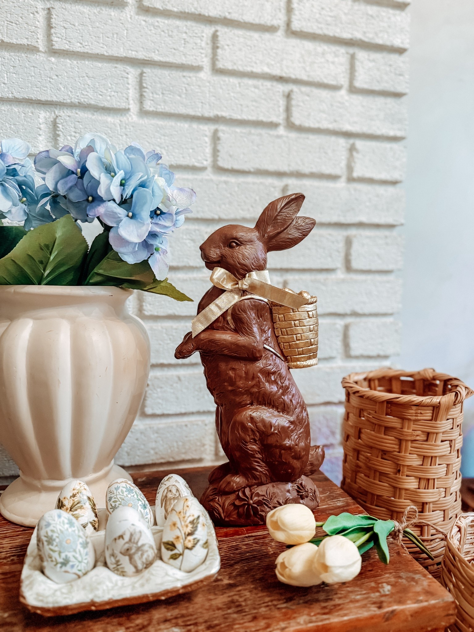 The sweetest little cottage corner for spring 🐰🌿
This chocolate bunny moment instantly became the star of this vignette—styled with thrifted finds, soft blue florals, and the prettiest patterned eggs for that collected, vintage feel.

It’s giving European cottage Easter without trying too hard 🤍
Mixing curated pieces with thrifted textures is always the magic formula.

Everything you need to recreate this cozy spring setup is linked in our storefront ✨

#ltkhome #cottagecoredecor #vintagestyle #springdecor #easterdecor
