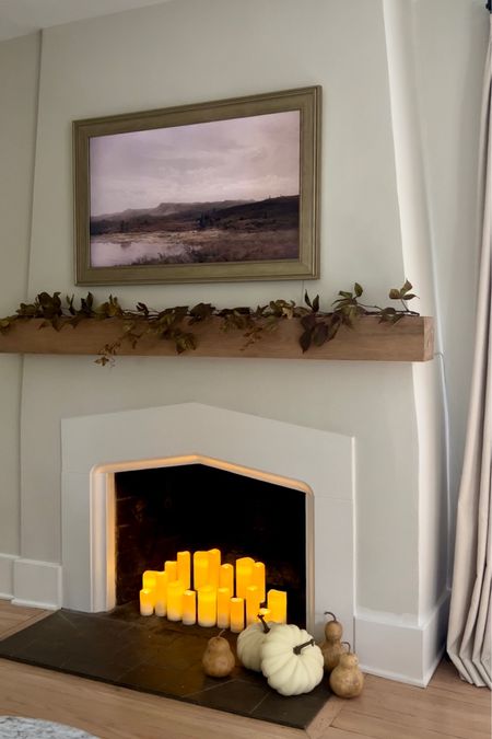 Candlelit fireplace decorated for fall. Flameless battery operated candles in cozy fireplace. Faux leaf stem mantle decor. #falldecor #flamelesscandles 

#LTKhome #LTKHoliday #LTKSeasonal