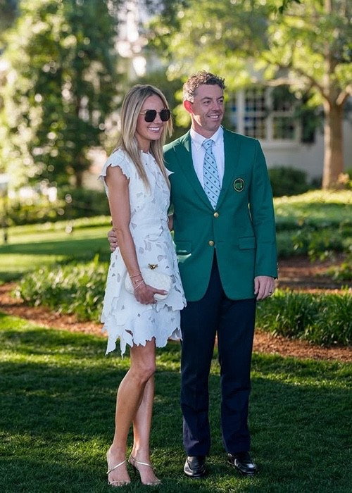Erica Stoll Embroidered Mini Dress in White. An embroidered mini dress cut from heavyweight cotton to create a sculptural shape on the body. Cap sleeves and cinched waist.  knot leather clutch