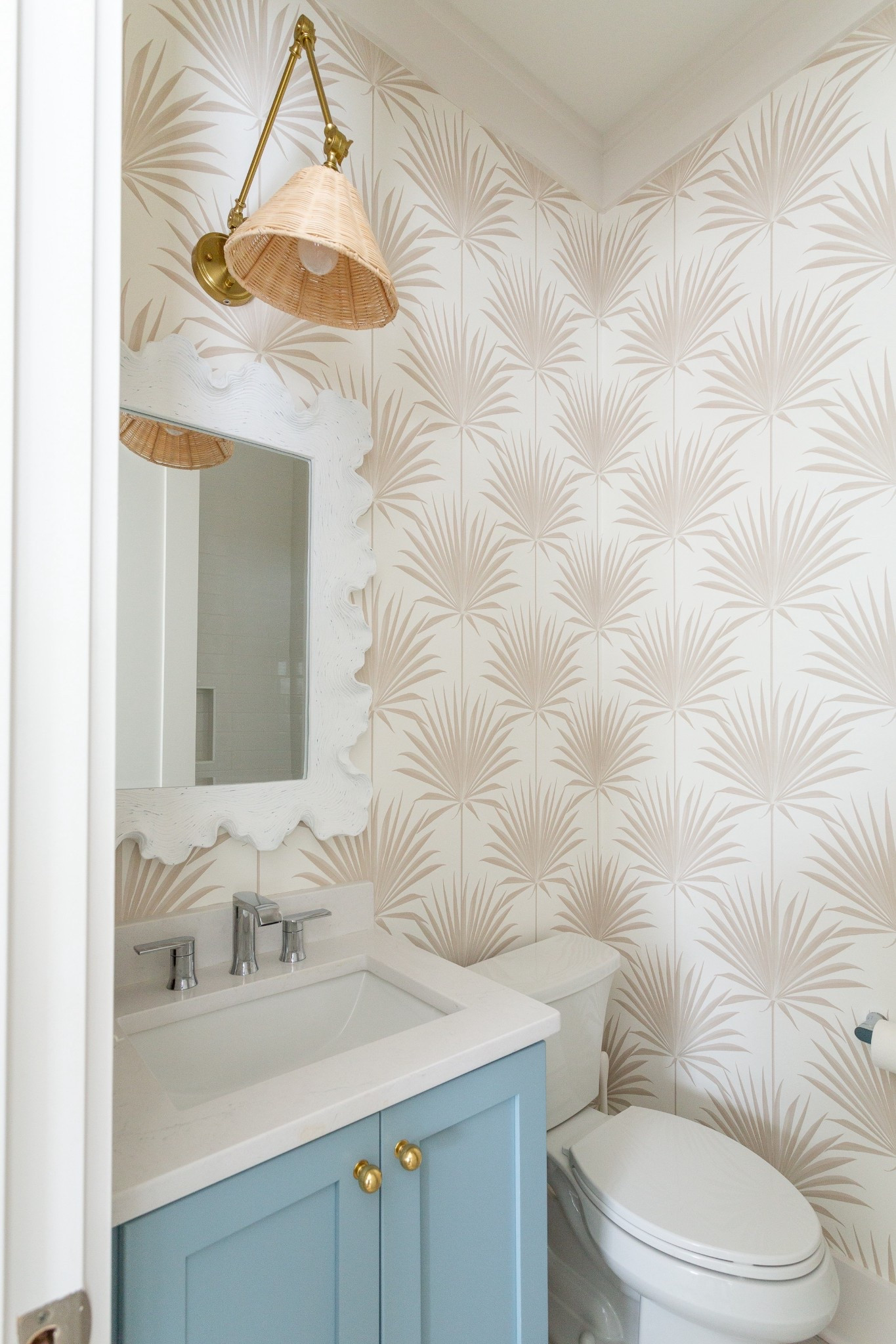*This wallpaper is currently on sale* A look at our wallpapered coastal guest bathroom! Includes this fan palm wallpaper, light blue cabinets, coral style mirror and rattan sconce light fixture! Get all the details here: https://lifeonvirginiastreet.com/coastal-bathroom-wallpaper/.
.
#ltkhome #ltkseasonal #ltkfindsunder50 #ltksalealert #ltkfindsunder50 #ltkfindsunder100 #ltkstyletip #ltkvideo Serena & Lily wallpaper, wallpaper ideas, coastal bathroom design 

#LTKHome #LTKSaleAlert #LTKSeasonal