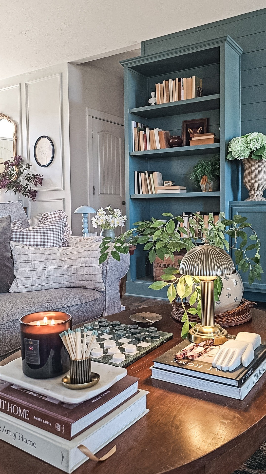 A cozy coffee table view with books, candles, a lamp and a game of checkers 

#LTKmomlife #LTKHome #LTKSaleAlert