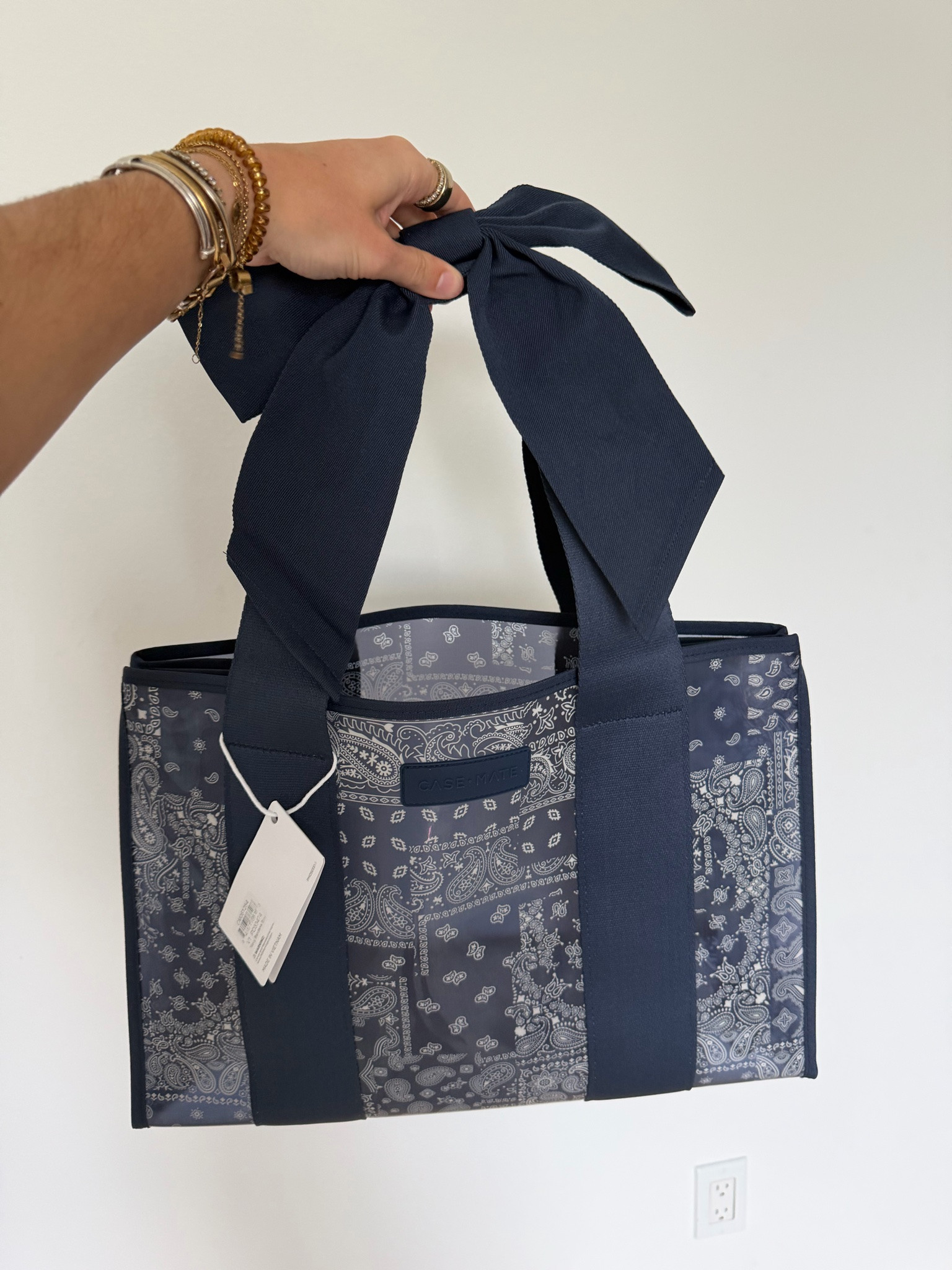 The Navy Bandana Bow Jelly Tote channels the effortless cool of an open road and wide-open skies with its Americana-inspired paisley print and oversized bow. Spacious yet lightweight, this bag is perfect for everything from errands and workdays to beach trips and travel. Fold it flat when you need a little more room in your suitcase, use it as your carry-on, or fill it with your daily essentials. This large tote bag is made from jelly-like TPU material that’s waterproof, wipes clean with ease, and holds up over time. The extra-wide jacquard straps and a covered snap closure make even a fully packed bag comfortable to carry. Inside, you’ll find a small zipper pouch and key leash to keep your phone, wallet, and daily essentials organized and always within reach. Fold it or fill it, this tote bag is ready for wherever you go! @case-mate

#LTKootd #LTKTravel #LTKSwim