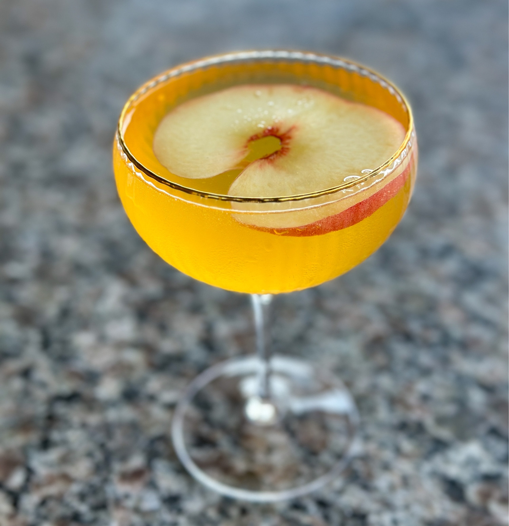 Kicking back sipping on this Peach Spritzer. Served in this Gold Rimmed Ribbed Coupe Glass  from World Market. @worldmarket #glassware #mocktails #fruitydrinks #peachspritzer 

#LTKhome
