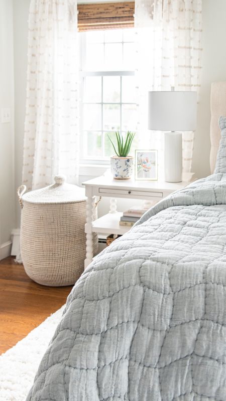 Coastal style bedroom decor with blue quilt, sheer curtains, seagrass storage basket, side table, and more home decor items

#LTKhome #LTKfamily