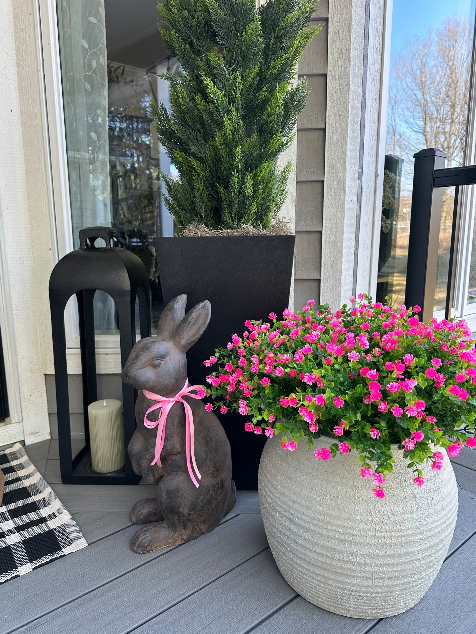 Spring Front Porch Decor with Lanterns, Bunny Statue + Pink Florals

Follow @farmtotablecreations on Instagram for more cozy home styling and seasonal finds.

This spring porch setup is the sweetest little welcome home moment 🌸 The layered entry rugs add the perfect touch of texture, and I love how the tall lanterns + evergreen planters create that clean, symmetrical look. The pink florals bring in just the right pop of spring color, and the bunny statue is such a fun seasonal accent without feeling overdone.

These plastic, UV resistant flowers come 10 bundles per box and I used 3 boxes (30 bundles total) in my 14” pot— and as you can see, they look incredibly full and realistic. Such an easy way to get that fresh spring look with zero upkeep.

Everything is simple, neutral, and easy to recreate for an inviting front porch refresh!

#springdecor #frontporchdecor #outdoordecor #porchstyling #entrywaydecor #lanterns #planters #doormat #springporch #seasonaldecor


#LTKSaleAlert #LTKHome #LTKSeasonal

#LTKHome #LTKSeasonal #LTKSaleAlert