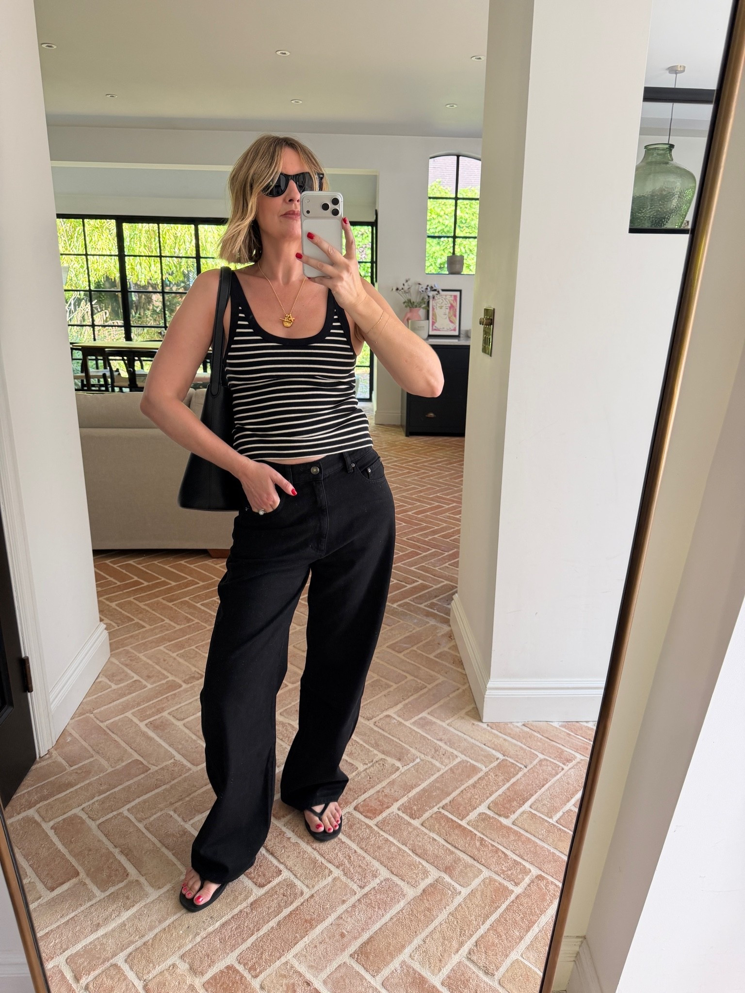 striped tank top, black and white striped top, ribbed striped tank, black wide leg jeans, black wide leg denim, black trousers, gold pendant necklace, layered gold jewelry, black slouchy tote, black shoulder bag, black flip flops, thong sandals, black sunglasses, nautical stripes, tonal black outfit, quiet luxury, elevated basics, effortless summer style, minimalist off duty look, ltkstyletip, ltkseasonal, ltksummer, ltkfindsunder100, outfit inspo, capsule wardrobe essentials

#LTKjeans #LTKeurope #LTKtravel