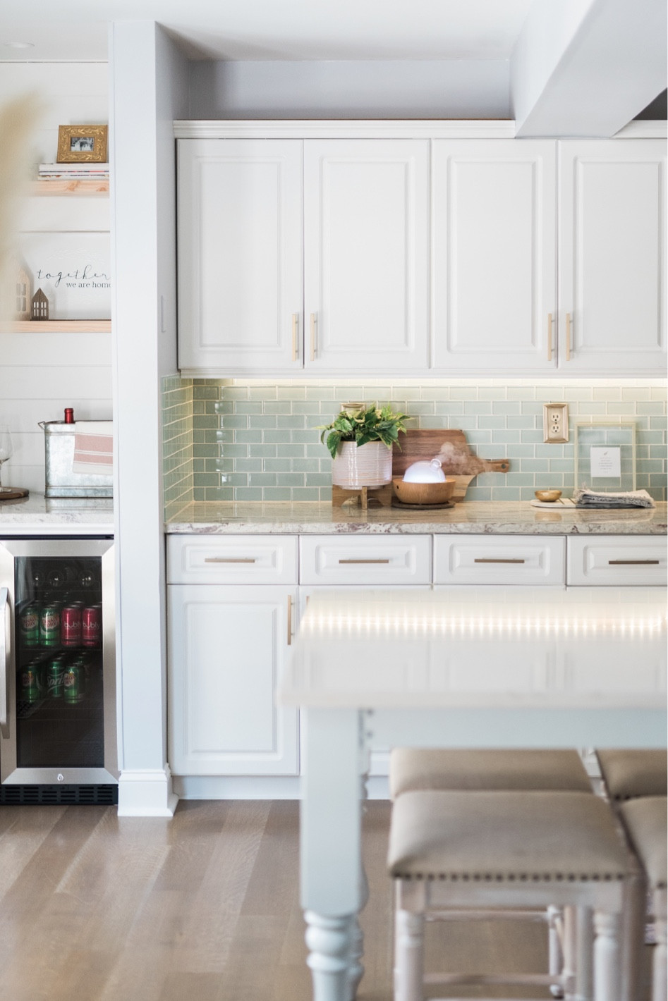 Kitchen Decor, wooden cutting board, gold metal frame, counter stool with nailhead trim, wine fridge, beverage refrigerator, champagne bronze pulls, cabinet hardware, gold pulls, pink ceramic planter with stand, ceramic pot, kitchen hand towel, Turkish hand towel, kitchen island, ceramic tile backsplash. 

#LTKhome #LTKstyletip #LTKFind