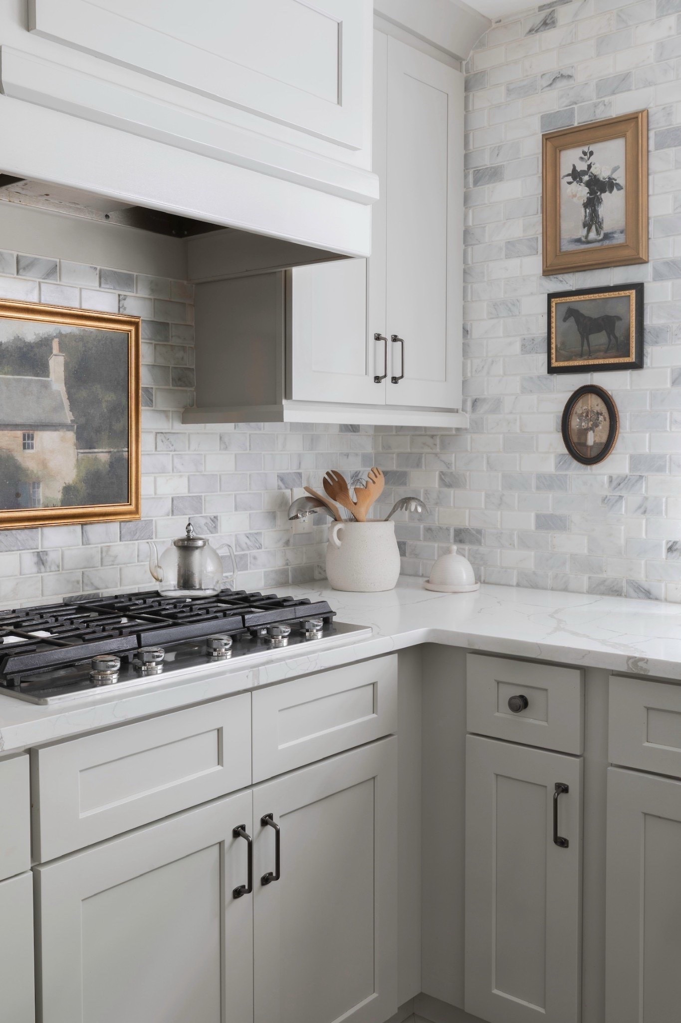 Classic charm in the kitchen 🤍 Featuring a marble subway tile backsplash, white shaker cabinets, and sleek marble countertops paired with a stainless steel gas cooktop. Styled with framed artwork, a ceramic utensil holder filled with wooden spoons, and a simple ceramic bell, this corner balances timeless design with warm details. ✨

#KitchenDesign #MarbleBacksplash #ShakerCabinets #MarbleCountertops #GasCooktop #FramedArtwork #CeramicDecor #KitchenInspo #TimelessInteriors #eanesinteriors



#LTKvlog #LTKdayinmylife #LTKHome