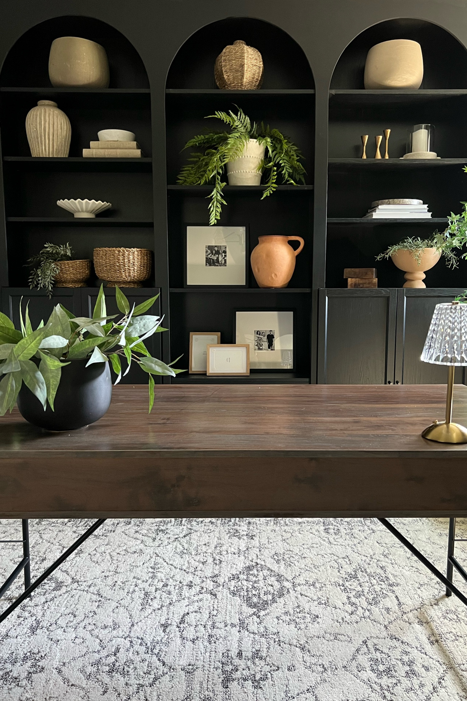 Home office view:
I’m loving the lighter rug in this moody space!
Let’s talk shelf styling for black bookcases: 
I have mainly light colored pieces here..terracotta vases and bowls, linen cover books, woven vases. 
Shelf styling, modern organic decor 

#LTKhome