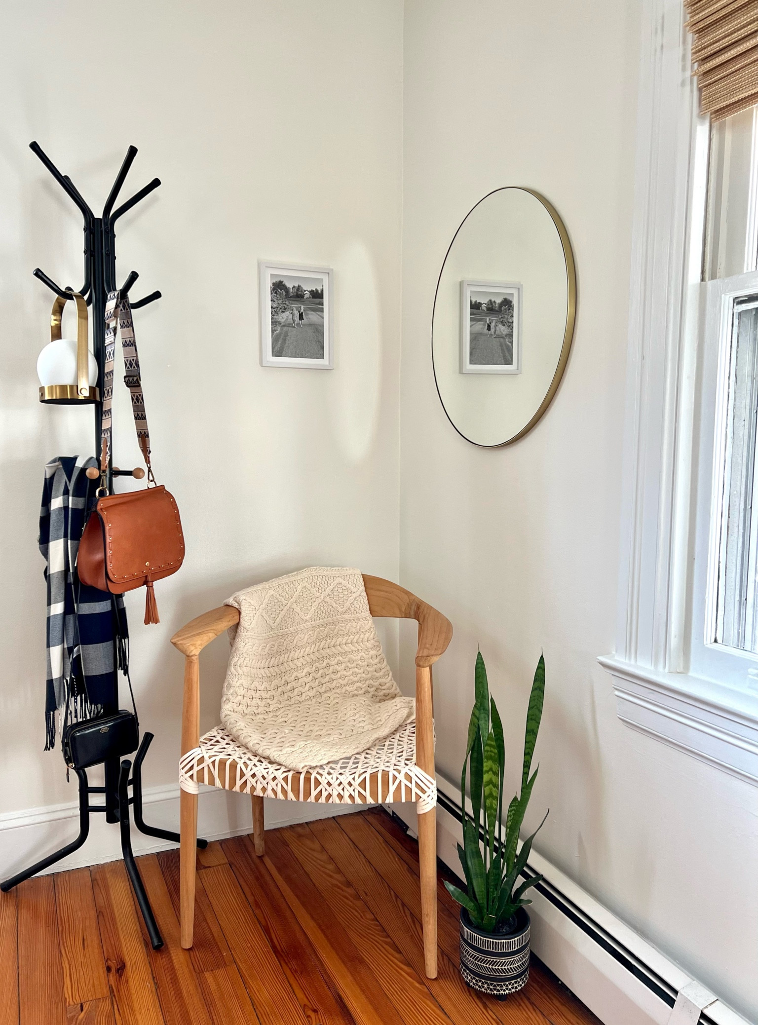 Corner nook with boho minimal design:
Cream leather bamboo accent chair, chunky throw blanket, round gold mirror, sansevieria plant, Mixtiles print, black matte coat rack with bamboo wood knobs (have linked similar), camel crossbody bag, bamboo blinds we installed DIY, and hanging LED table lamp that we use to light up this little area. 

#LTKhome #LTKsalealert #LTKstyletip
