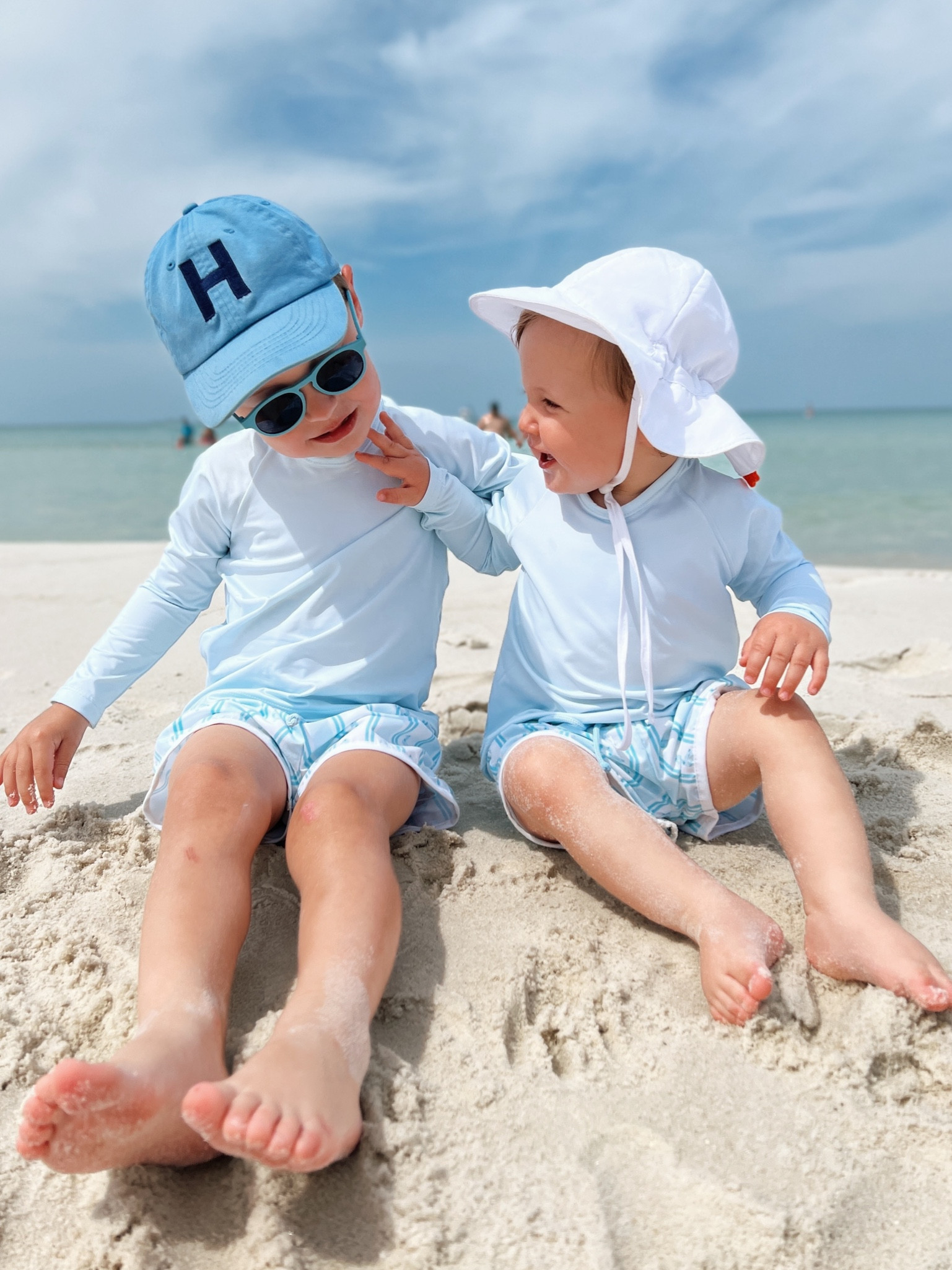 Brothers in matching baby’s blue rash guard and blue and white ducky swim trunks 

#LTKswim #LTKbaby #LTKkids