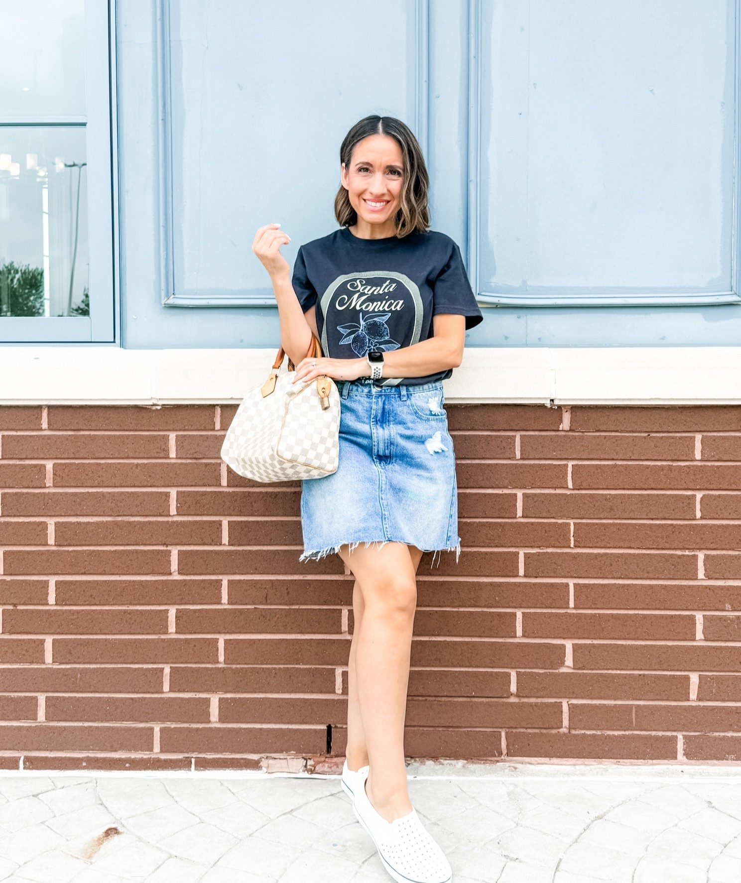 Black graphic T-shirt with the cutest Flower detail  and Santa Monica written on the front. 
Light wash jean skirt. This skirt runs big. It’s from last year. So I’ll share few cute options. 
White Native Water Shoes. These are really comfy.  
Neutral handbag. 
Petite style 
Petite outfit

#LTKPetite #LTKOver40 #LTKmomlife