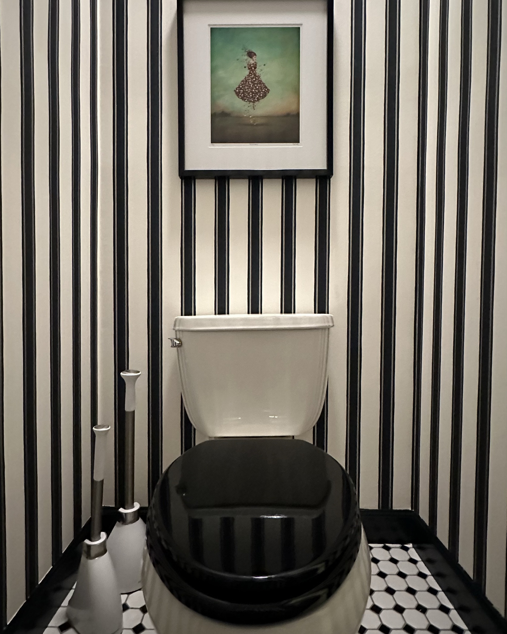 Toilet rooms or powder rooms are great places to go bold with a design, especially with wallpaper. I chose to add this pretty block print stripe paper and juxtaposed it with the checkered floors. Some extra bells & whistles include a soft close toilet lid, nickel toilet paper holder and plate covers and bold black trim.

#LTKHome #LTKStyleTip