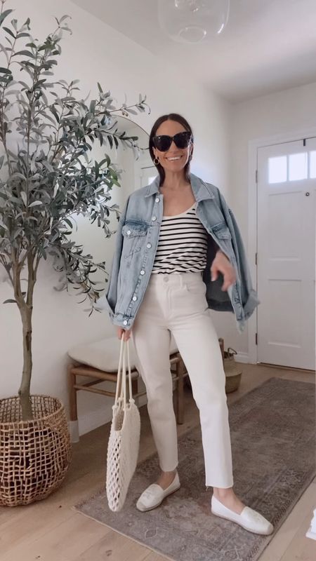 Spring outfit in oversized denim jacket (wearing my regular size), cream straight leg jeans (I went up a size) striped tank (Tts), gold earrings, crochet bag 

#LTKstyletip