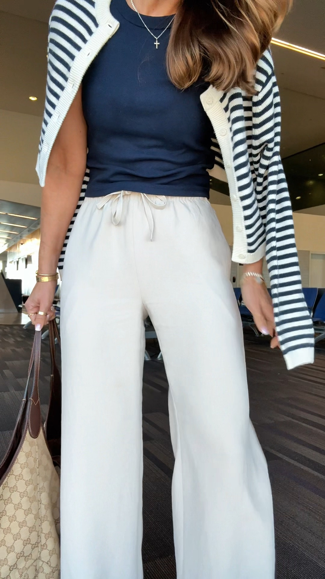 My travel outfit of the day! Aritzia The Lodge Pant - Crepette. Size XS regular, color ‘Metropolis Taupe’. Comes in short and tall, too. Wrinkle resistant with an elastic waist and high-rise. Aritzia t-shirt in XS. Aritzia striped cropped cardigan in 2XS. Jelly ballet flats are whole sizes only. I’m a 6.5 and sized down to a 6 per reviews. Business casual. Elevated casual. Workwear. Coastal outfit.