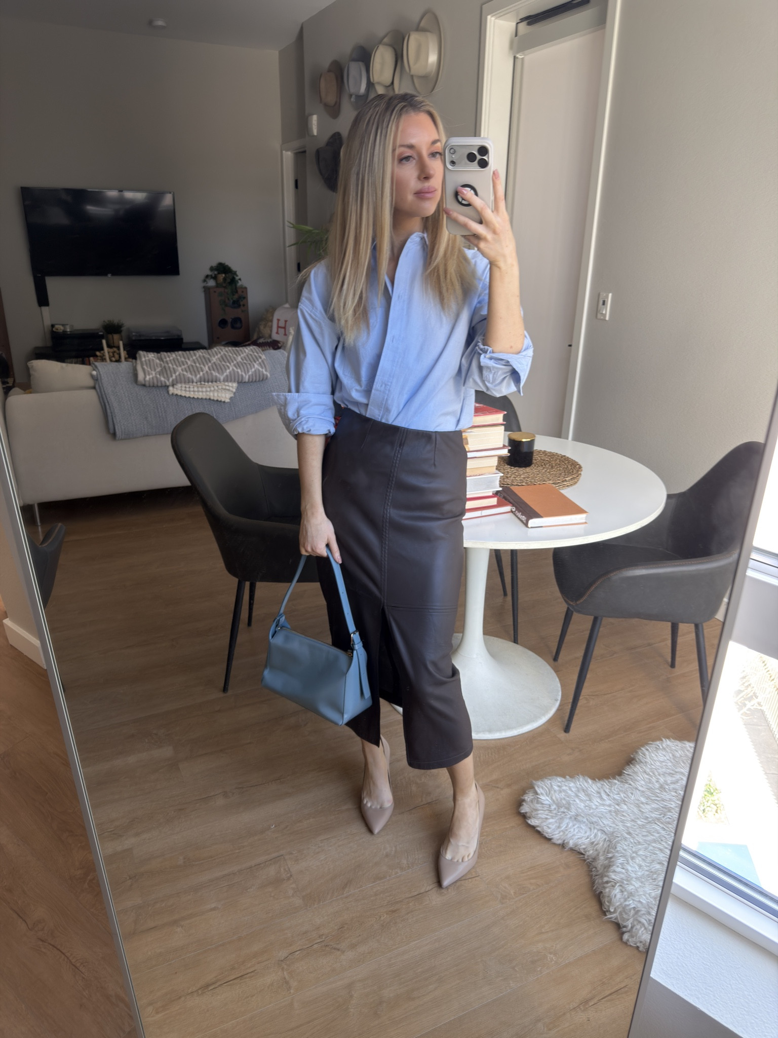 Classic workwear outfit featuring a light blue button-down shirt, brown leather midi skirt, pointed-toe heels, and a structured handbag. I love this timeless combination for a polished office outfit that still feels effortless. Linking everything in my LTK.

#LTKWorkwear #LTKootd