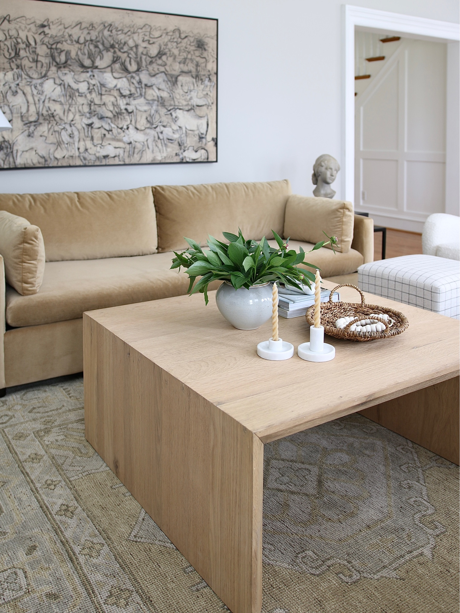 I have two West Elm Marin couches. I got this one first and loved it so much I got one in white as well. I have a review on them on my blog (stefanasilber.com). The coffee table is from Crate & Barrel. I love this wall art called Migration by Kader Boly but is currently out of stock. The rug is Safavieh and is hand knotted wool.